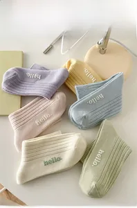 Flat lay of colorful mid-tube cotton socks with hello embroidery in six pastel colors