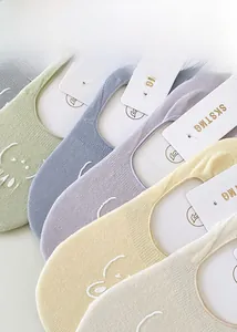 Detailed close-up of colorful cotton no-show socks with cute embroidered smiley face design