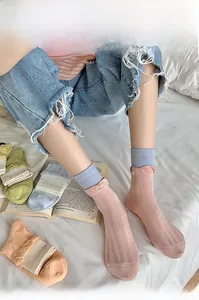 Detail of macaron color mid-tube socks with wavy cuffs and delicate Sun embroidery