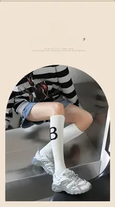 Détail de chaussettes de sport en coton avec lettre B noire et motif à rayures chic