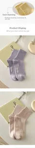 Close-up of knit cotton socks in pastel colors featuring Hello text and ribbed texture