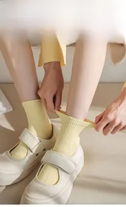 Close-up of elastic ribbed cuff on light yellow cotton sock with excellent stretchability
