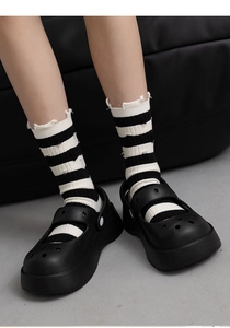 Detail of black and white striped mid-calf socks with vintage distressed frayed edges