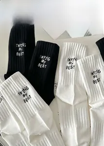 Detailed view of ribbed knit socks featuring white and black embroidered lettering