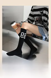 Détail de chaussettes hautes noires en coton avec broderie blanche ea de style sport