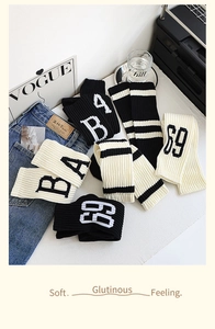 Détail de jambières en tricot avec motifs de lettres et rayures sur un magazine de mode