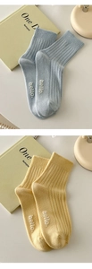 Detail of cotton ribbed mid-calf socks with hello lettering in light blue and yellow