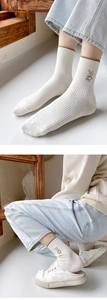 Close-up of white ribbed crew socks featuring a brown rabbit embroidery detail