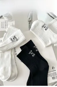 Detail of ribbed knit cotton socks featuring Tryin My Best embroidery on white background