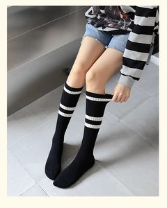 Gros plan sur des chaussettes hautes noires en coton avec rayures blanches style sport