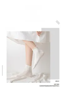 Detail showing white cotton socks with delicate ruffle trim and breathable texture