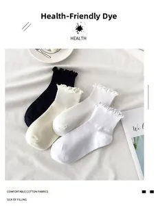 Close-up of cotton ruffled socks in black and cream beige on a minimalist background