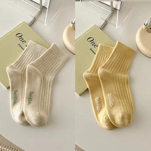 Cozy crew socks in milk white and soft yellow with hello embroidery and ribbed texture