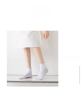 Close-up of white ruffle trim ankle socks with soft knit texture and MORE STYLE text