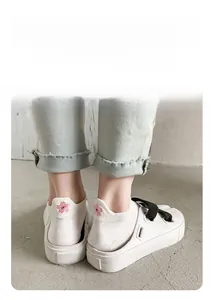 Gros plan sur la broderie fleur de cerisier rose au talon de chaussettes d'été