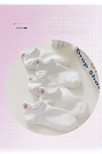 Gros plan de chaussettes en maille blanche avec broderie de fleurs de cerisier