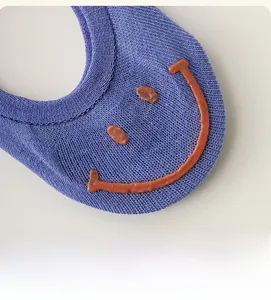 Détail macro du talon de chaussette bleue avec motif smiley en silicone antidérapant