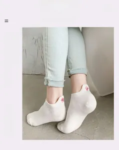 Gros plan sur les chaussettes invisibles en coton blanc avec broderie cerisier rose