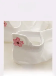 Gros plan détaillé d'une broderie de fleurs de cerisier rose sur le talon des chaussettes