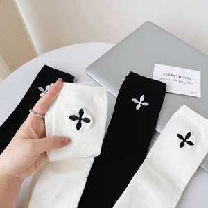 Japanese style high-tube socks with clover embroidery in minimalist black and white