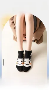 Detail of black cotton summer socks with a large orange and white smiley face pattern