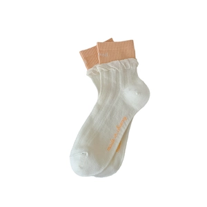 Mid-calf cotton socks in cream with orange double cuff and 'made in creamy' text print