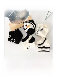 Detail of five pairs of cotton low cut socks featuring funny smiley face and penguin patterns