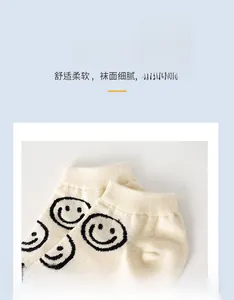 Detail of light beige ankle socks featuring black smiley face pattern and soft elastic cuffs