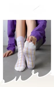 Detail showing the high-elasticity cuff of purple and white plaid cotton socks