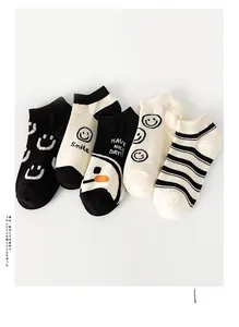 Detail view of 5-pack women's low cut cotton socks with black smiley face and stripe patterns