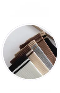 Detail of multi-color striped crew socks featuring ribbed cuffs in various neutral tones
