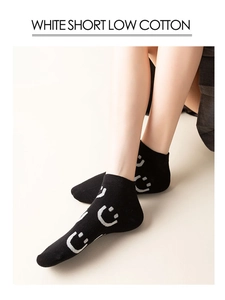 Close-up of black low-cut cotton socks with white smiley face jacquard patterns