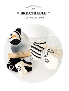 Detail of breathable women's cotton socks featuring stripe patterns and a smile face design