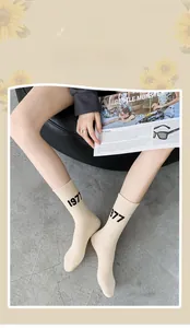 Close-up of beige 1977 letter print mid-calf cotton socks in vintage collegiate style
