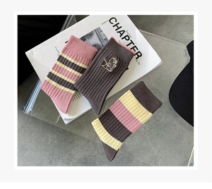 Detailed view of pink and brown striped cotton socks with cute cat embroidery details