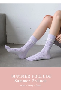 Close-up of lavender cable-knit socks with white stripes on the ribbed cuff