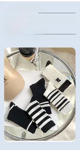 Close-up of R embroidered cotton socks with black and white striped patterns