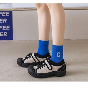 Details von königsblauen Baumwollsocken mit C-Stickerei und Plateau-Sneakern am Fuß