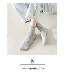 Detailed close-up of grey knitted crew socks with ribbed cuffs and marl texture