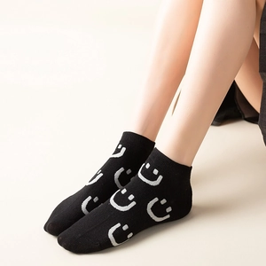 Women's black low-cut cotton socks featuring white smiley face patterns on the ankle