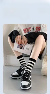 Close-up of black and white striped cotton mid-calf socks with detailed R embroidery