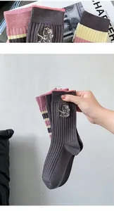 Close-up of ribbed cotton crew sock with cute cat embroidery and contrast cuff detail