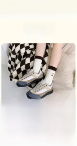 Close-up of brown striped mid-calf socks with cute bear embroidery and retro sneakers