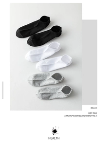 Close-up of three pairs of ribbed cotton ankle socks in black, white, and grey colors