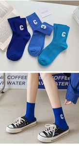 Detailansicht der Baumwollsocken mit weißer C-Stickerei und vertikaler Rippenstruktur