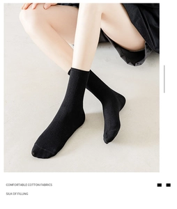 Close-up of black mid-calf socks with ribbed knit texture and premium cotton fabric