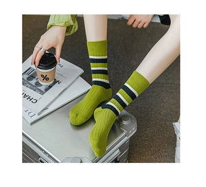 Details von grünen gerippten Crew-Socken mit schwarz-weißen Streifen im Lifestyle-Look