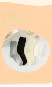 Detail of four pairs of ribbed mid-calf cotton socks in gray black beige and white