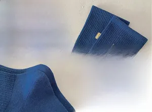Detailed close-up of dark blue ribbed knit fabric and elastic cuffs with yellow accents