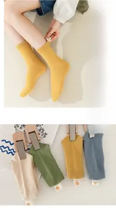 Detail of ribbed knit cotton socks in various colors with cute smiley face fabric tags